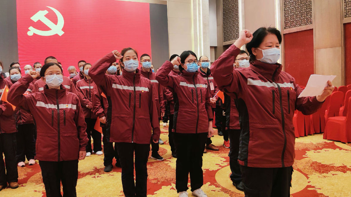 2020年3月22日，福建首批援鄂医疗队福建医大附一医院队员连宁芳（左一）面向国旗庄严宣誓，成为一名光荣的中国共产党预备党员