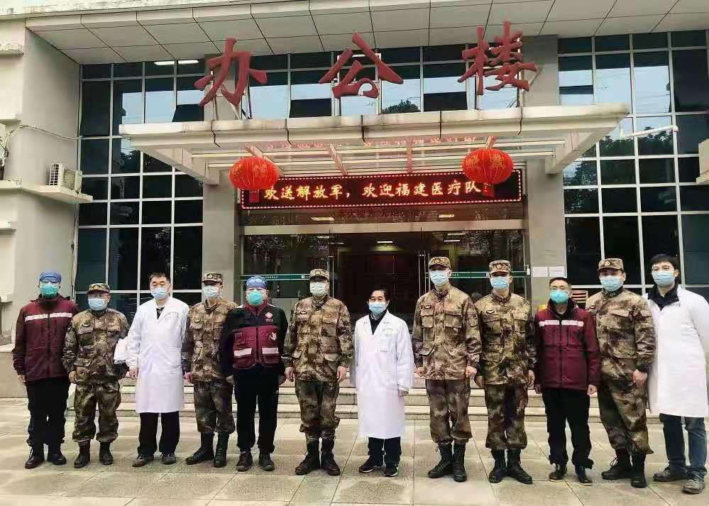 2020年2月3日，福建省首批援鄂医疗队与陆军军医大学医疗队交接工作后在武汉金银潭医院办公楼前合影