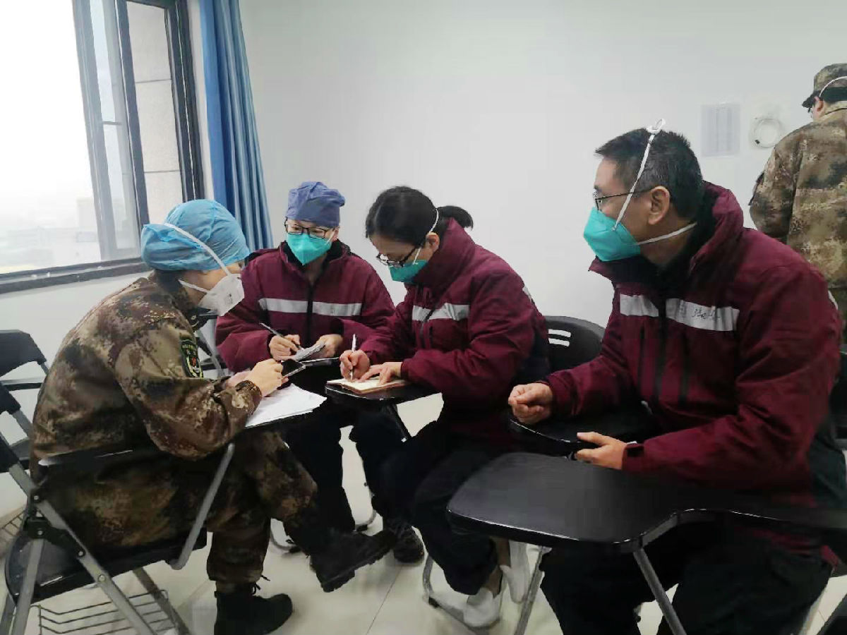 2020年2月3日，福建省首批援鄂医疗队福建医大附一医院队员与陆军军医大学医疗队队员在武汉金银潭医院示教室交流患者情况