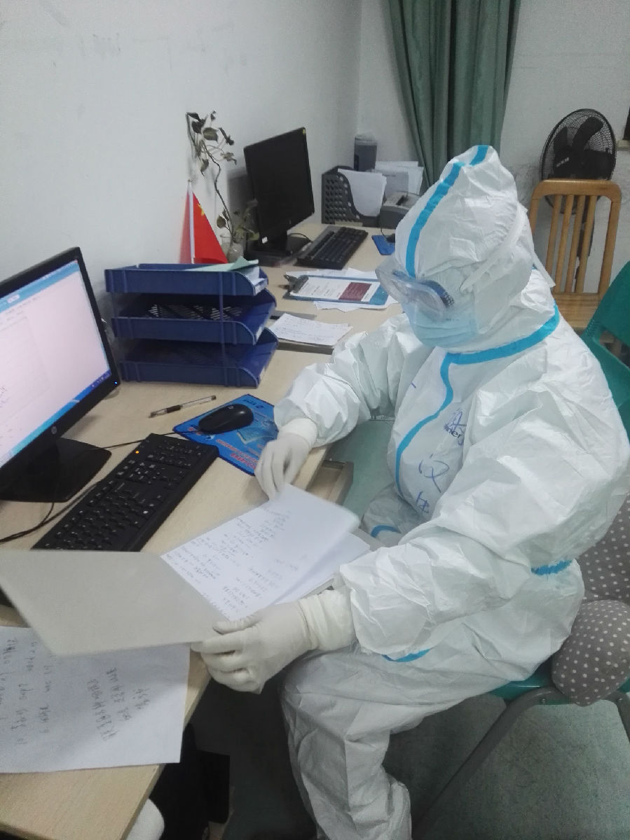 2020年2月1日，福建省首批援鄂医疗队福建医大附一医院队员谢汉生在武汉市中心医院后湖院区医生办公室查看当天记录的患者病情并与同事讨论治疗方案