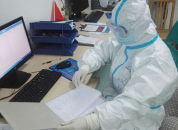 2020年2月1日，福建省首批援鄂医疗队福建医大附一医院队员谢汉生在武汉市中心医院后湖院区医生办公室查看当天记录的患者病情并与同事讨论治疗方案