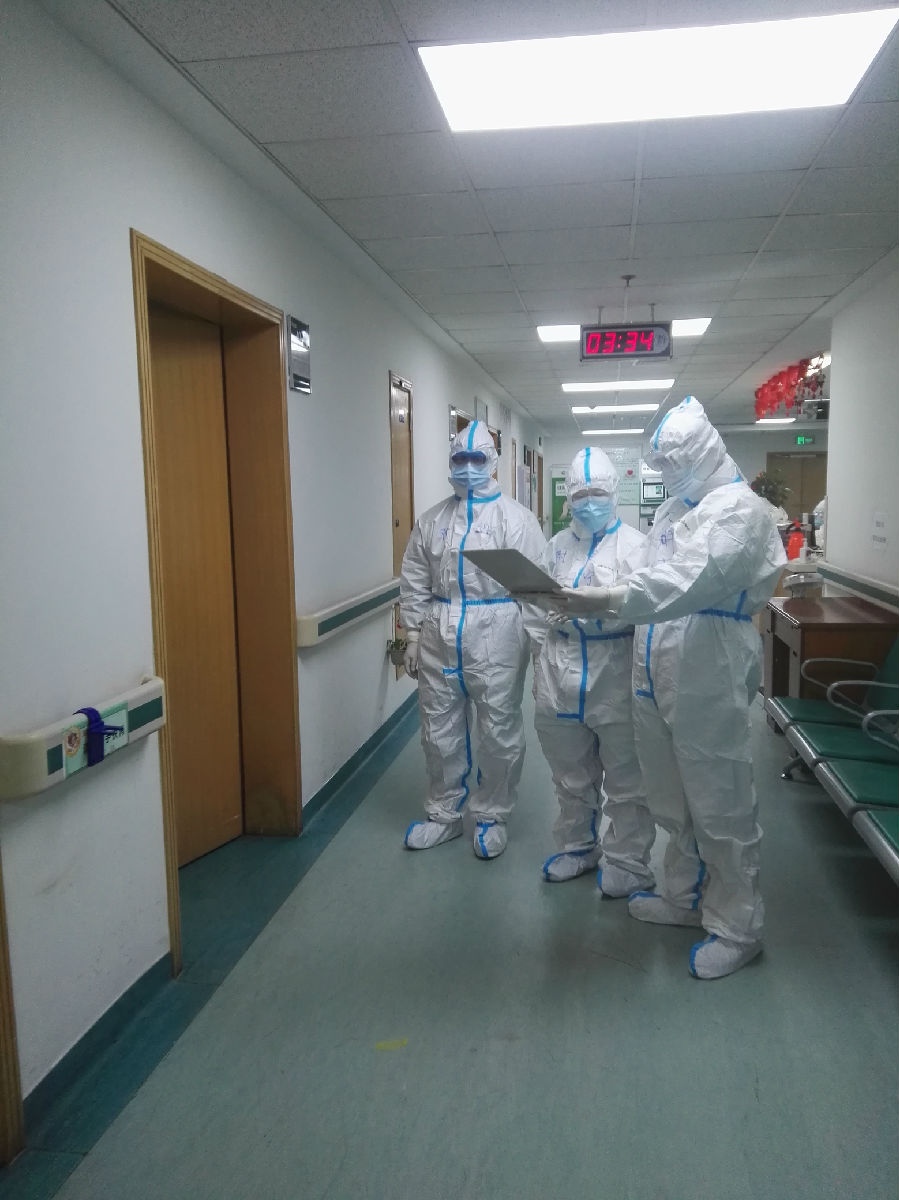 2020年2月1日，福建省首批援鄂医疗队福建医大附一医院3名队员在武汉市中心医院后湖院区进行查房，图为在病房外讨论病情的场景