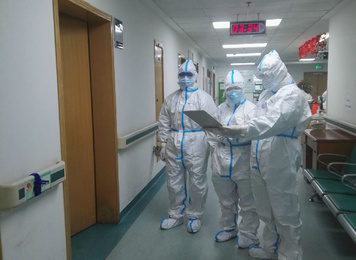 2020年2月1日，福建省首批援鄂医疗队福建医大附一医院3名队员在武汉市中心医院后湖院区进行查房，图为在病房外讨论病情的场景