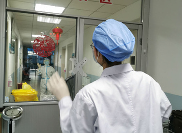 2020年2月4日，工作人员隔着隔离门互相鼓劲