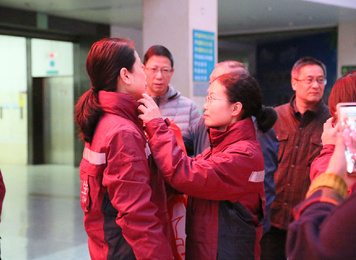 2020年1月27日，福建首批援鄂医疗队福建医大附一医院队队员连宁芳（右）出征前在医院外科楼为同为队员的赵建铭（左）整理着装